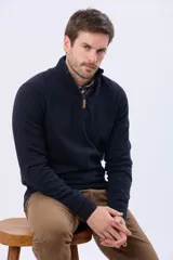 Buzo tejido de algodón color azul marino, con cuello alto y cierre frontal parcial con detalle de cuero en el tirador.