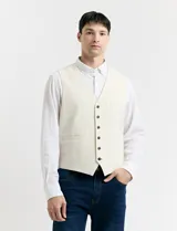 Chaleco de vestir color crudo, con cuello en V y cierre frontal con botones. Posee dos bolsillos ribeteados en la parte inferior y uno tipo ojal en el pecho.