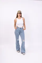 Pantalón de jean celeste de corte acampanado con roturas en las rodillas.