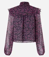 Blusa de chiffon negra con estampado floral liberty en tonos rosados, cuello alto con lastex y volados en los hombros. Mangas largas con puños ajustados.