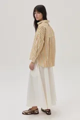 Camisa a rayas verticales en tonos mostaza y blanco, de corte clásico y manga larga.