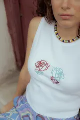 Musculosa crop de algodón elastizada color blanco, con bordado de dos rosas en el frente.