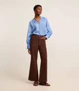 Pantalón wide leg de sarga color marrón chocolate, con cintura alta, trabillas, bolsillos delanteros y traseros, cierre con botón y cremallera, y costura vertical delantera.