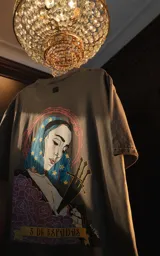 Remera gris de manga corta y cuello redondo, con calce oversize y estampado sublimado de una ilustración con una mujer, espadas y rosas.