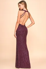 Vestido largo de fiesta color borgoña, cubierto de lentejuelas brillantes, con escote halter profundo y espalda descubierta.