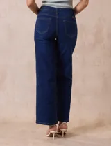 Jean de pierna ancha, color azul oscuro, con pretina con pasadores, botón y cierre. Delantera y trasera con bolsillos.