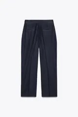 Pantalón azul marino de corte recto, confeccionado en lino. Presenta tiro alto, pinzas delanteras, bolsillos laterales y falsos bolsillos de vivo en la parte trasera.