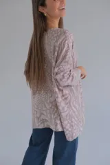 Sweater beige con estampado animal abstracto, de cuello redondo y manga larga caída.