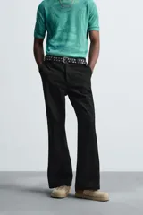 Pantalón negro de corte recto con bordados florales a tono, bolsillos laterales y traseros de vivo. Cierre frontal con cremallera y botón.