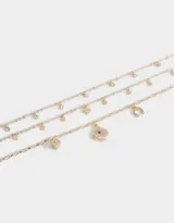 Collar dorado multicadena con dijes de strass con motivos de suerte: herradura, trébol, carta y dado.