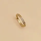 Anillo dorado en oro 10k con circonias engarzadas en la mitad superior.