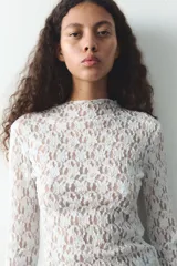 Camiseta negra de encaje con cuello alto y mangas largas.