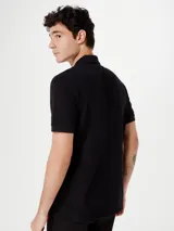 Camiseta tipo polo de manga corta, color azul oscuro, con cuello y tapeta de dos botones.