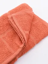 Repasador de cocina color salmón con diseño de cuadrados en relieve.