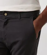 Pantalón masculino de sarga color beige, corte slim, con cierre de botón y cremallera, trabillas en la cintura y bolsillos delanteros y traseros.