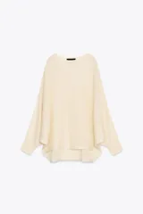Sweater color crema de tejido de punto liso, con cuello barco y mangas anchas que se estrechan hacia la muñeca.
