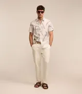 Camisa de hombre confeccionada en voil color crudo con estampa floral estilo outline en azul. Tiene cuello inglés, abotonado delantero y manga corta.