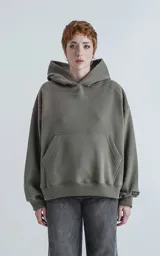 Hoodie color verde militar de frisa gamuzada 100% algodón, de calce oversize crop. Tiene bolsillo canguro y capucha forrada.