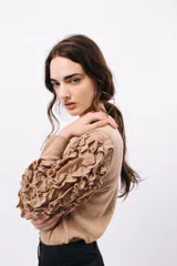 Remera negra de punto con mangas largas abullonadas con volantes.