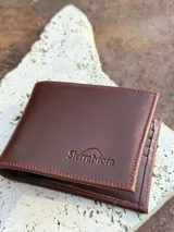 Billetera de cuero color marrón con el logo de la marca SierraMora grabado en la parte inferior.