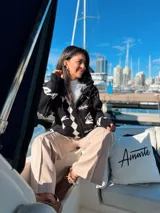 Camperón tejido oversize con capucha, bolsillos y estampa de ciervo.