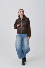 Campera estilo aviador con cuerpo de eco-cuero marrón oscuro y mangas y cuello de corderito (teddy) marrón. Presenta cierre frontal metálico y dos bolsillos frontales con solapa de corderito.