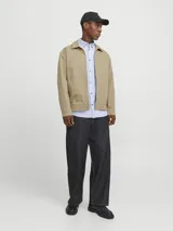 Sobrecamisa shacket color beige con cierre de cremallera y diseño resistente. Confeccionada en tejido liviano, delgado y transpirable de poliéster reciclado. Presenta cuello clásico, mangas largas con puños abotonados, cierre con cremallera y bolsillos frontales funcionales.