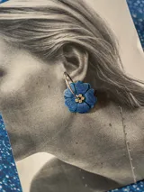 Aros de acero con forma de flor color azul con glitter y centro dorado con strass. Diseño 2en1 con doble flor de distinto color en cada lado.