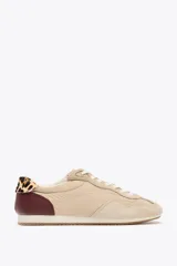 Zapatillas deportivas color beige con detalles en marrón y estampado animal print en el talón. Cierre con cordones y suela de 1,5 cm de altura.