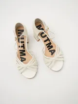 Sandalias de charol con estampado floral, taco cuadrado y correa fina en el tobillo.