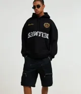 Bermuda negra de estilo baggy, confeccionada en mezcla de poliéster y algodón. Presenta doble trabilla, bolsillos cargo laterales con cremallera y detalles de cremallera visibles.