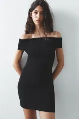 Vestido corto negro de tejido de punto, con escote recto y hombros descubiertos.