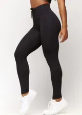 Calza deportiva negra de tiro alto con cordón ajustable en la cintura y logo estampado en la pierna.