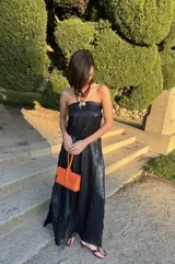 Vestido largo strapless de seda estampada en tonos azules y negros, entallado al cuerpo con espalda baja descubierta.