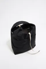 Bolso de mano negro de nailon con estructura blanda, doble asa de mano y asa de tejido regulable. Cuenta con logo metálico BIMBA Y LOLA, acabados metálicos, bolsillo interior, cierre de cordón e interior con etiqueta de tejido.