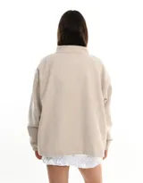 Chaqueta beige de simil paño con cierre frontal y bordado manual de flores, sol y nubes.