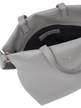 Cartera tote de mujer color gris claro, con acabado granulado y cierre de cremallera. Cuenta con dos asas superiores y una correa cruzada ajustable tejida con inscripción de la marca.