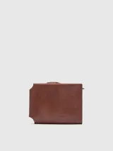 Billetera desplegable de cuero craquelado color marrón, con curtición vegetal. Cierre con broche, compartimento para billetes, monedero con cremallera y tarjetero.