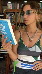 Collar tipo gargantilla compuesto por pequeñas cuentas de acrílico blancas, con dije de cuerno italiano (cornicello) esmaltado en turquesa y adornado con dos piedras rojas redondas. Los herrajes son dorados.