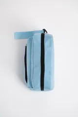 Necesser celeste rectangular de tela acolchada, con cierre superior y bolsillo frontal con cierre. Tiene una correa de mano en un lateral.