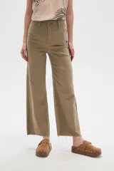 Pantalón de jean color beige, de corte flare y tiro alto, con terminación desflecada.
