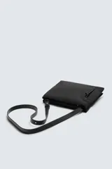 Bandolera negra de tejido técnico con compartimento principal con cierre de doble cremallera, bolsillo interior con cremallera y bolsillo frontal con cremallera. Tiene asa de hombro ajustable.