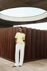 Camiseta blanca de algodón con cuello redondo, manga corta y detalle de flores con volumen a tono en el delantero.