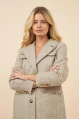 Tapado largo color beige con cuello solapa y corte recto. Cierre frontal con botones, detalles aplicados en la parte delantera, tajo en la espalda y bolsillos ojal con tapa. Con forro. Hecho en Uruguay con tela 100% lana fina sin teñir.