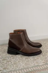 Bota corta color marrón con textura símil cuero de cocodrilo, caña baja, punta redondeada y taco cuadrado.