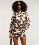 Minifalda de sarga con estampado animal print de vaca, cinturón largo con hebilla cuadrada y forro de bolsillo.