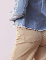 Campera de jean azul de la marca Baccini, con cuello solapa, abertura central con botones metálicos, bolsillos delanteros y ruedo desflecado.