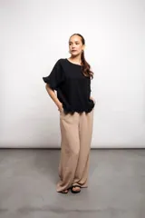 Blusa suelta color rosa con volados en mangas y ruedo. Confeccionada en lino y viscosa.