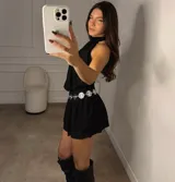 Minivestido blanco con cuello halter, corte ajustado en la cintura y falda con volados.