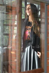 Remera negra de algodón con estampa frontal de la frase "More Amor Por Favor" en color naranja y un corazón rosa.